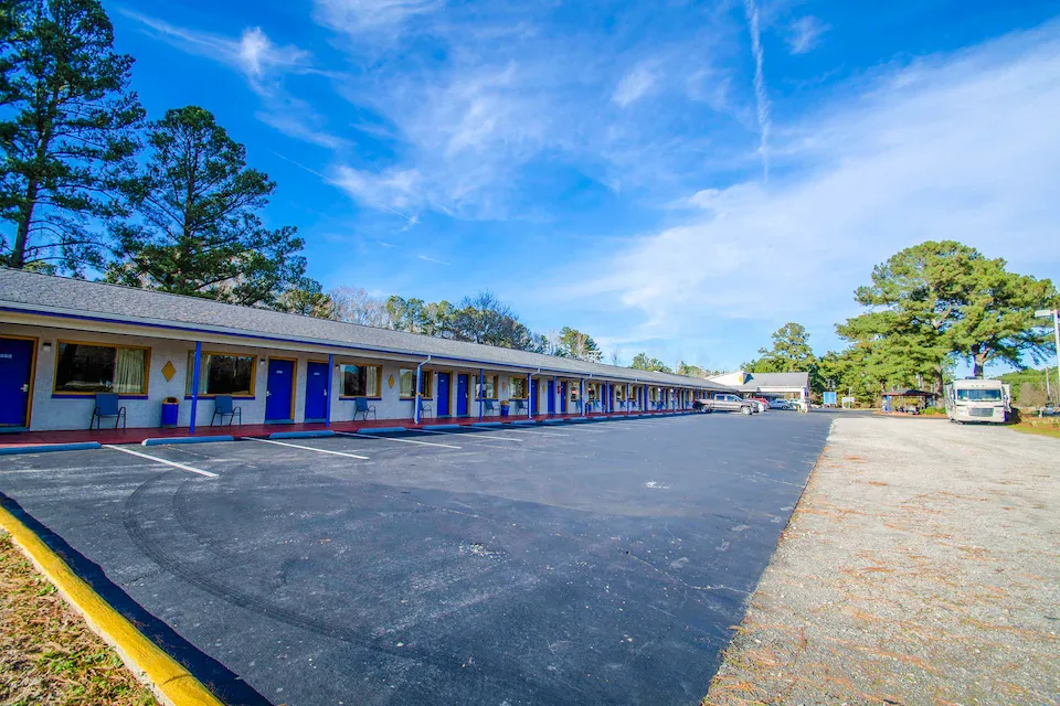 Exterior motel building with blue doors and white walls in Plymouth, NC at Sportsman Inn