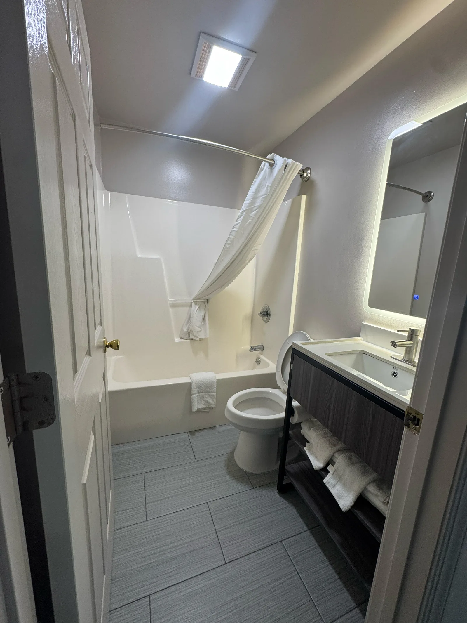 Modern bathroom with shower, toilet, and dark vanity at Sportsman Inn