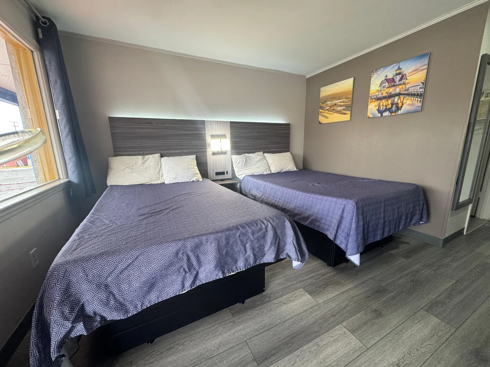 Standard double full room with two beds, purple bedding, and windows at Sportsman Inn