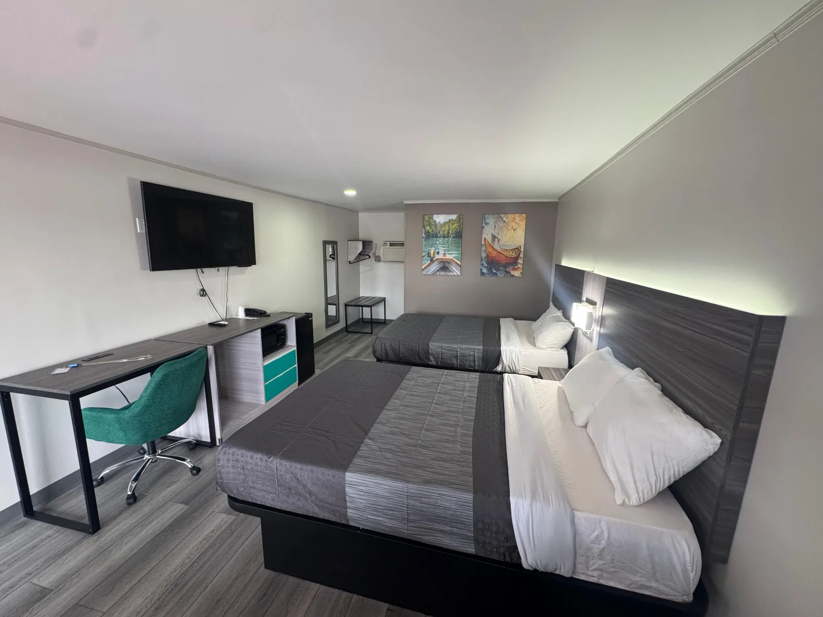 Double queen room with desk, TV, and modern décor at Sportsman Inn