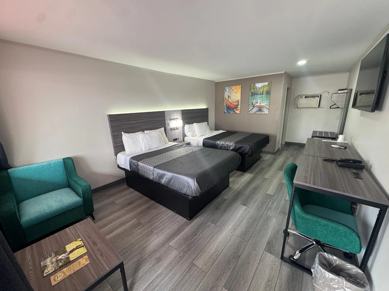 Superior Double Queen Room with two beds, teal chairs, and work desk at Sportsman Inn