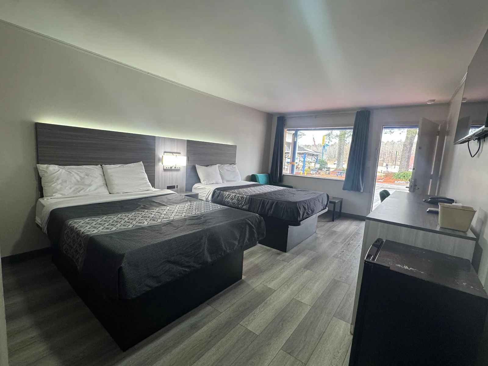 Double queen bedroom with modern furnishings and large windows at Sportsman Inn