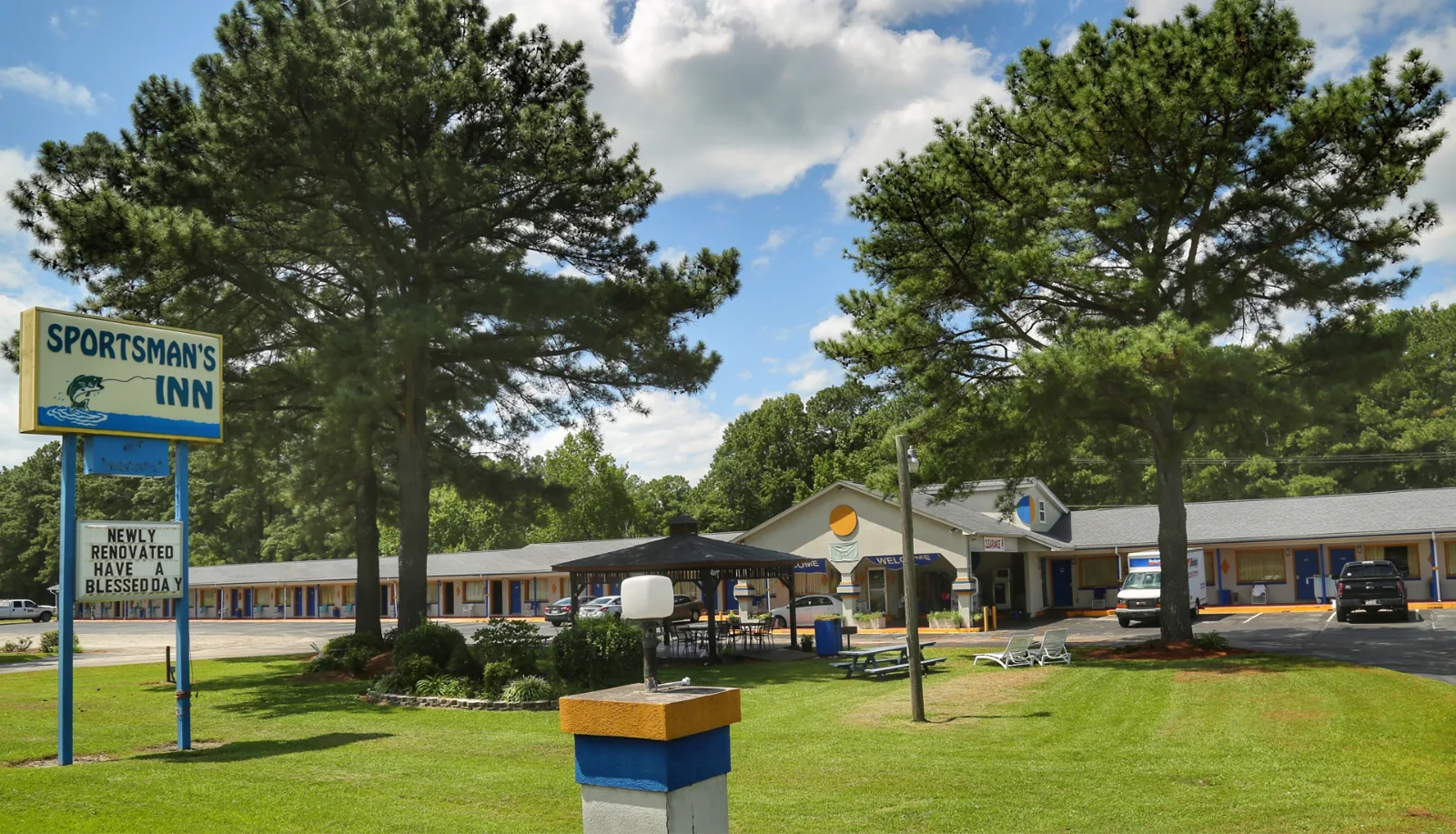 Exterior view of newly renovated motel with blue and yellow signage at Sportsman Inn