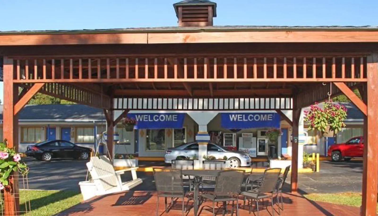 Covered patio with dining table and chairs overlooking welcome entrance at Sportsman Inn
