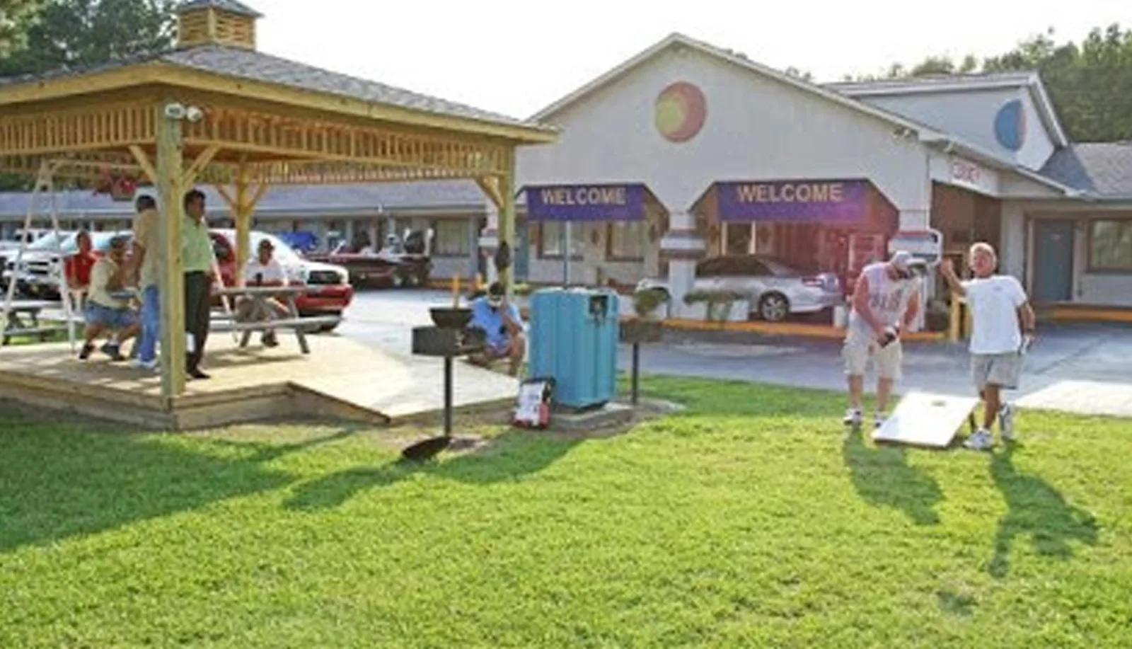 Outdoor recreational area with cornhole games and picnic shelter at Sportsman Inn