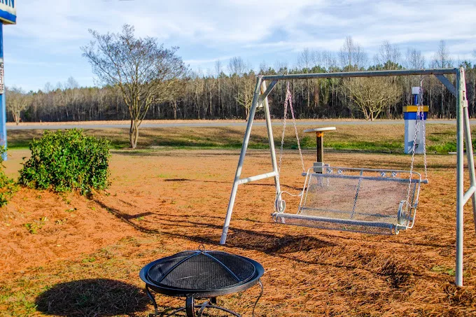 Outdoor playground with swings and trampoline at Sportsman Inn